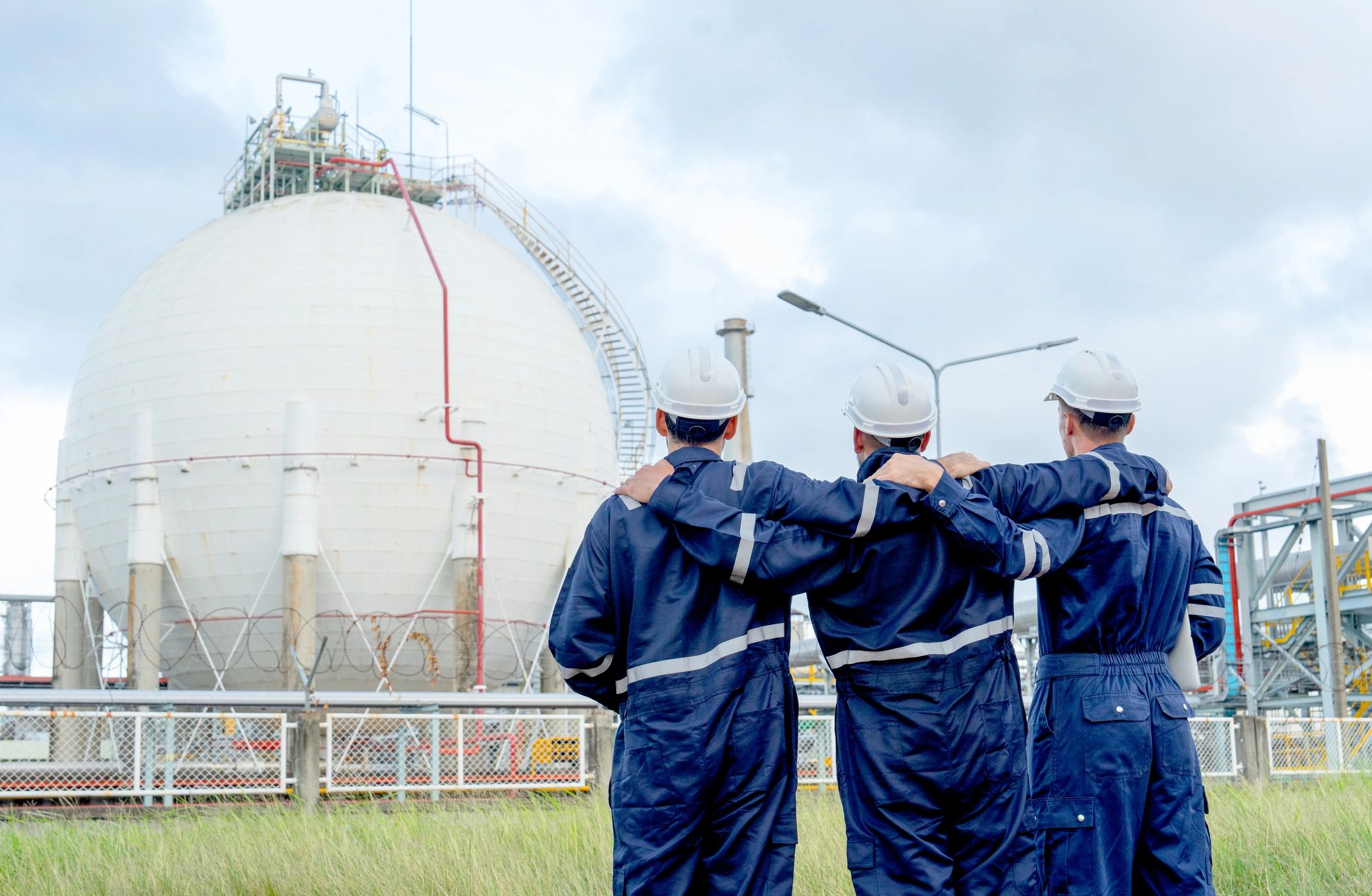 Technicians in protective gear reviewing conditions at an industrial work site
